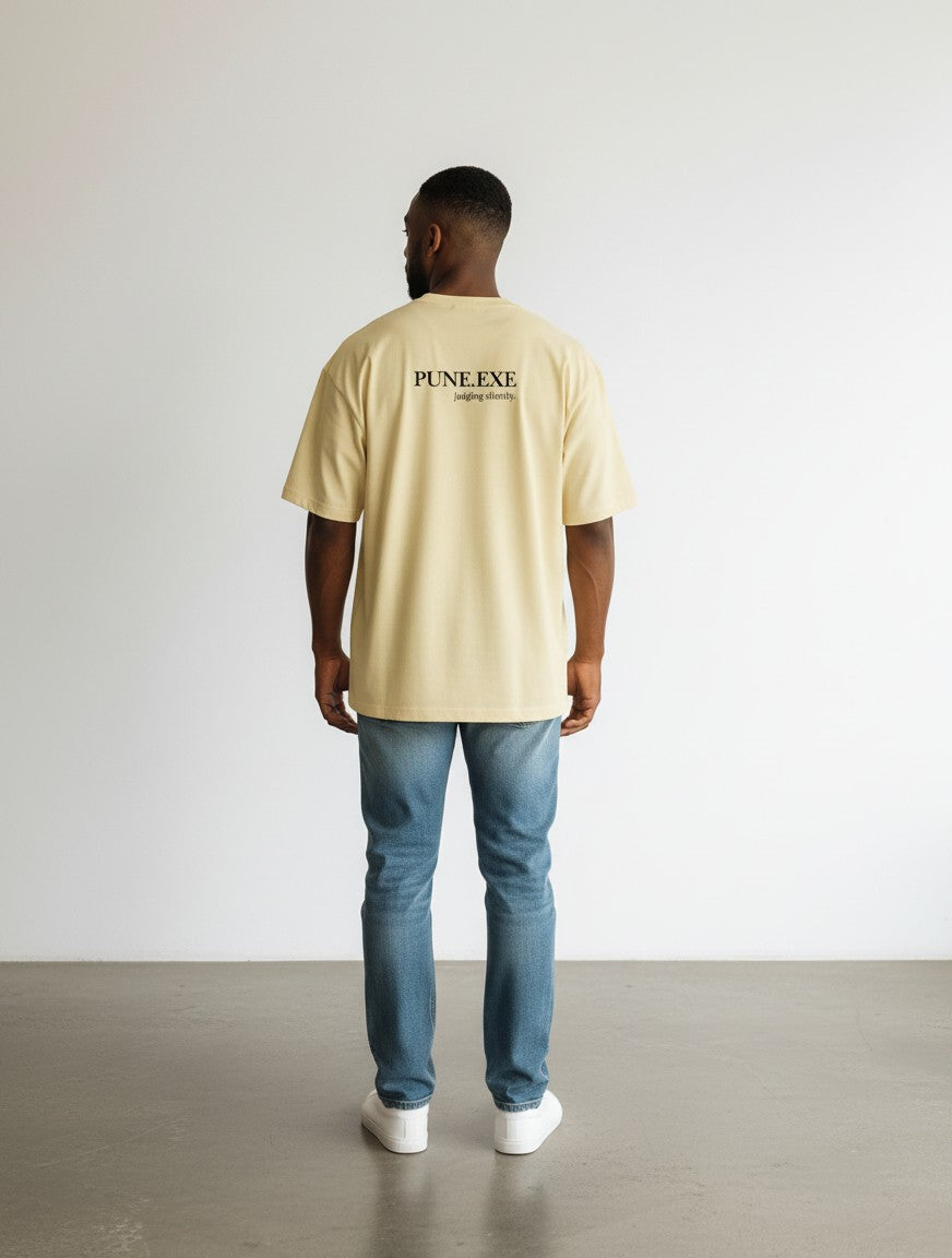 mi-DONE oversized beige cotton t-shirt with PUNE.EXE graphic print on back worn by a man with blue jeans