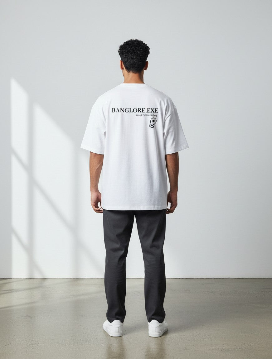 Back view of a man wearing a white mi-DONE oversized cotton t-shirt with Bengaluru graphic print and drop shoulders.