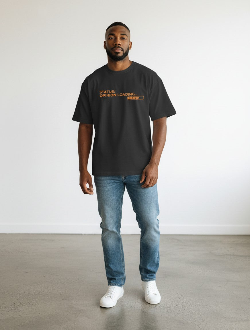 A man wearing a black mi-DONE oversized cotton t-shirt with an orange Status: Opinion Loading graphic print.