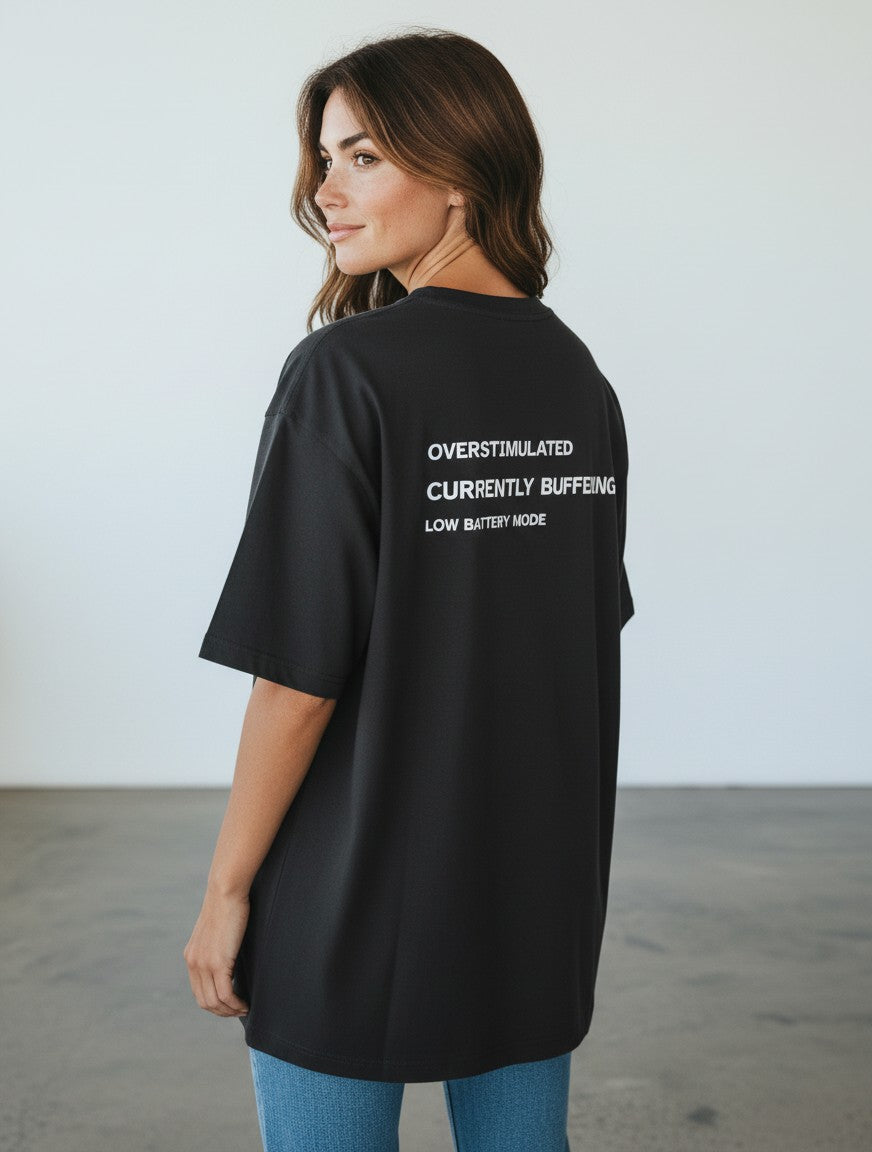 mi-DONE black oversized cotton t-shirt with Overstimulated text print on the back worn by a woman