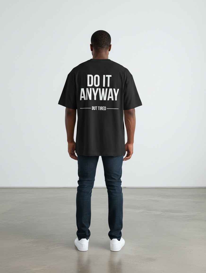 mi-DONE black oversized cotton t-shirt with white Do It Anyway But Tired graphic print on back, worn by a man