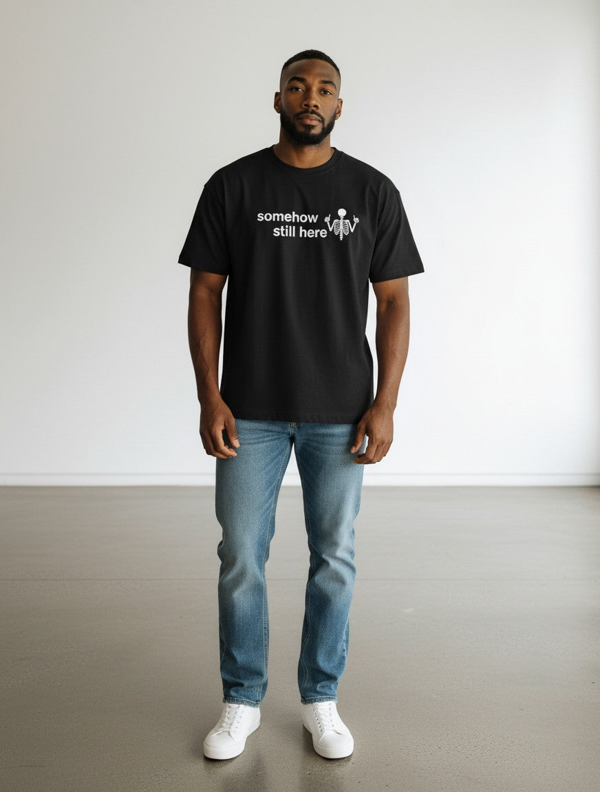 mi-DONE black oversized cotton t-shirt with somehow still here skeleton graphic print worn by a man with blue jeans