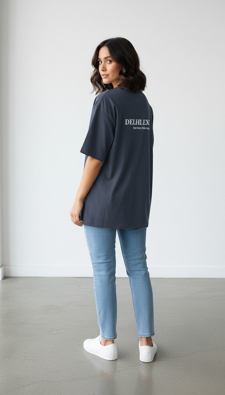 Model wearing a charcoal grey oversized mi-DONE cotton t-shirt with back graphic print, paired with light blue jeans.