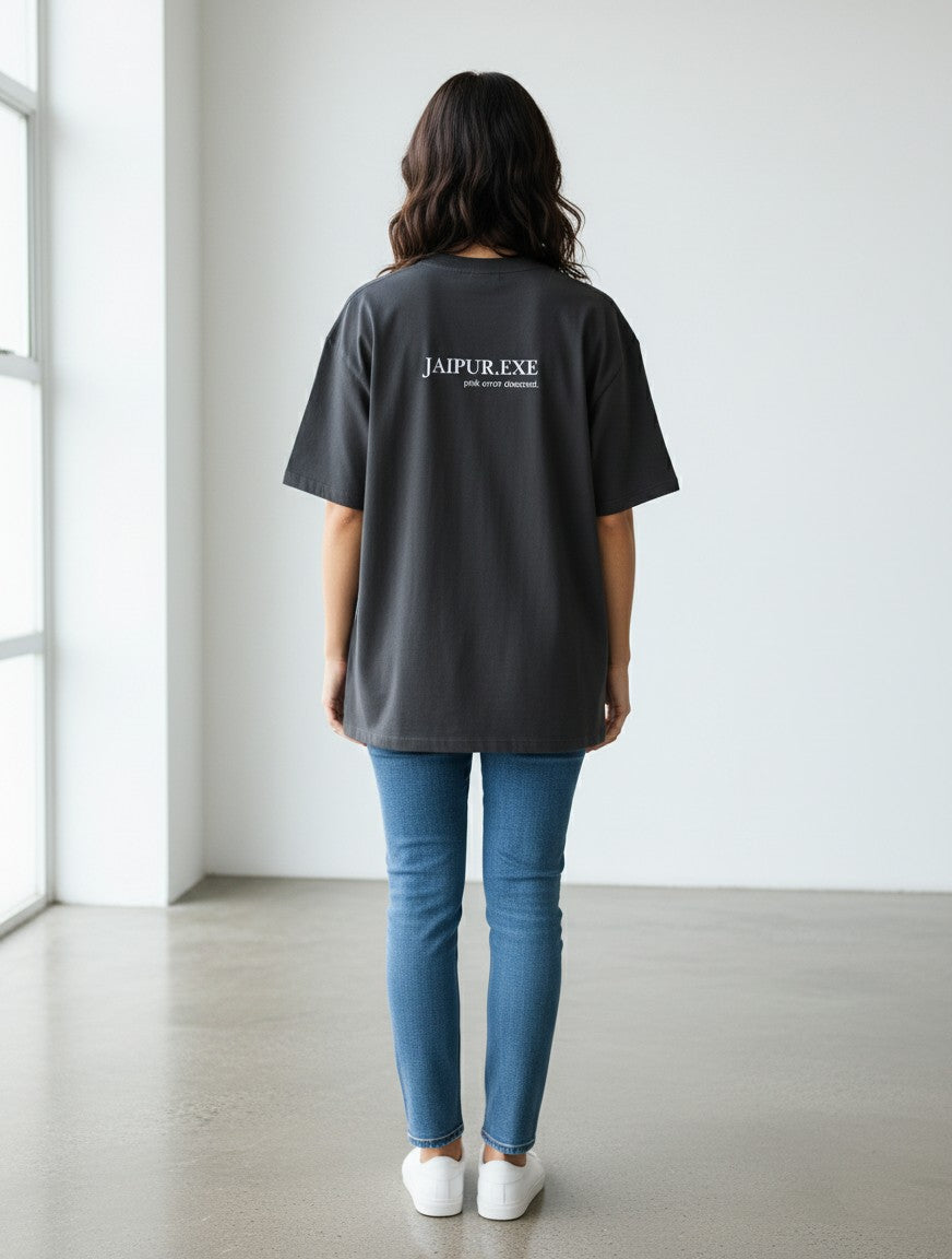 mi-DONE oversized charcoal grey cotton t-shirt with Jaipur.exe graphic print on back, worn by a woman with jeans