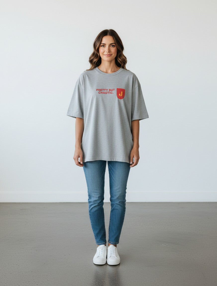 Woman wearing a grey mi-DONE oversized cotton t-shirt with Pretty But Chaotic text and a red patch logo