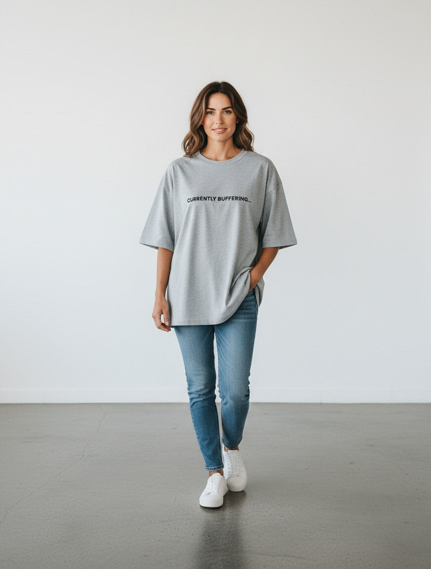 mi-DONE grey oversized cotton t-shirt with Currently Buffering print worn by a woman with blue jeans and white sneakers