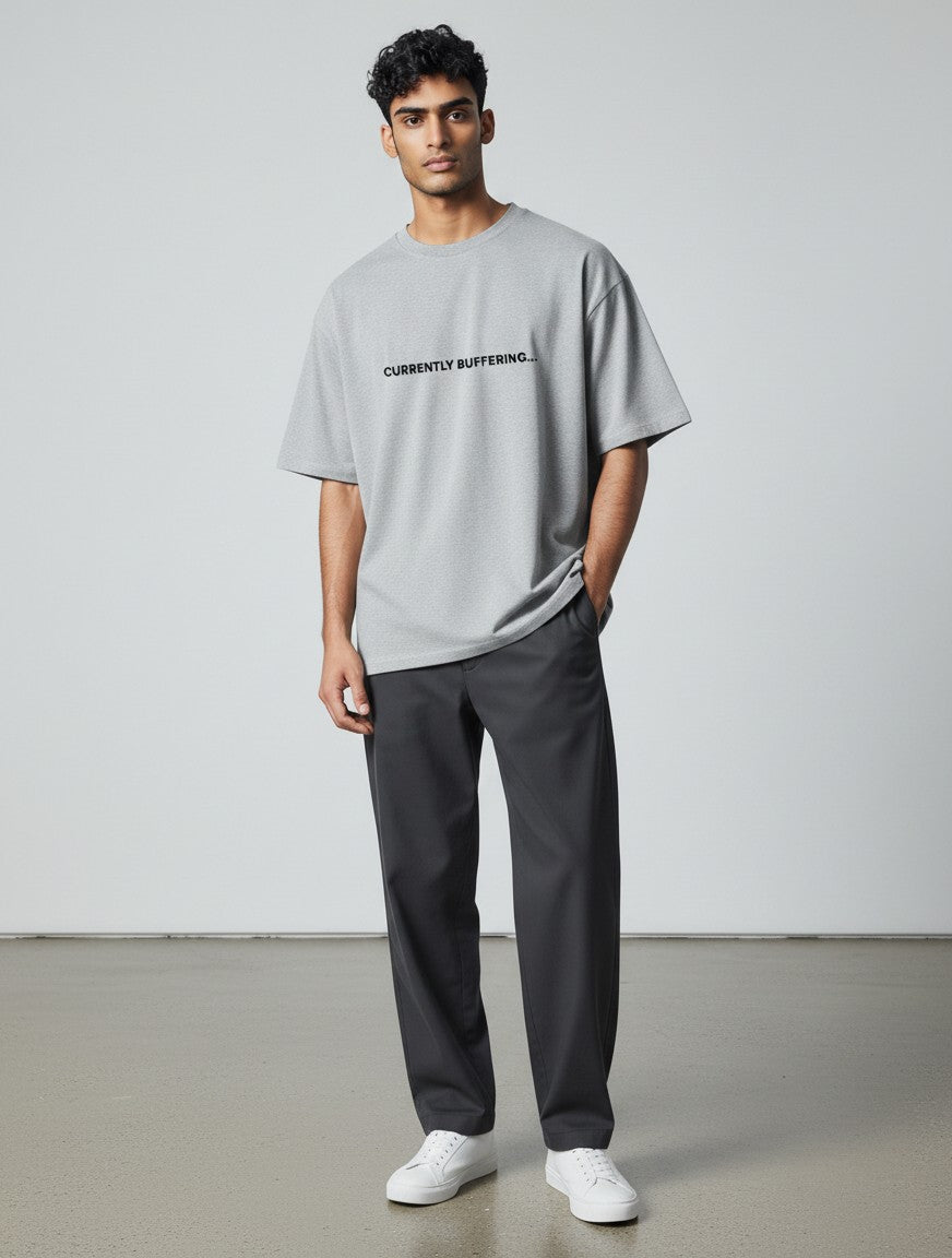 mi-DONE grey oversized cotton t-shirt with Currently Buffering print worn by a man with dark trousers and white sneakers