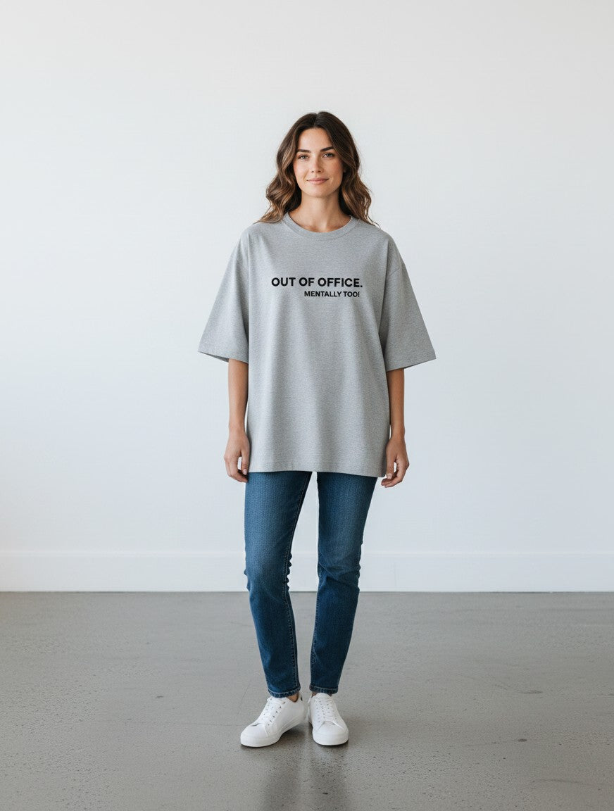 mi-DONE grey oversized cotton t-shirt with Out of Office print worn by a woman with blue jeans and white sneakers
