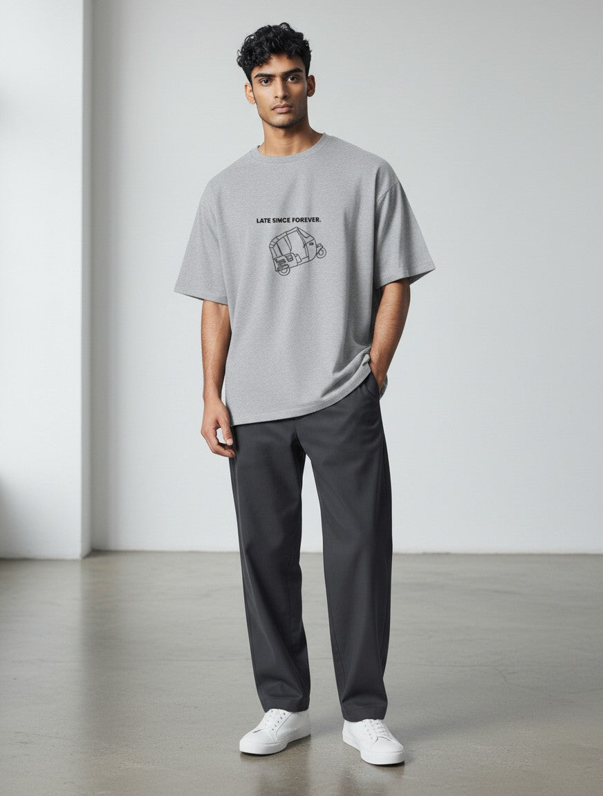 Model wearing a grey mi-DONE oversized cotton t-shirt with a Mumbai rickshaw graphic print and drop shoulders.