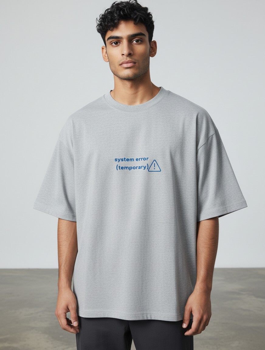 A man wearing a grey mi-DONE oversized cotton t-shirt with a blue System Error graphic print on the chest.