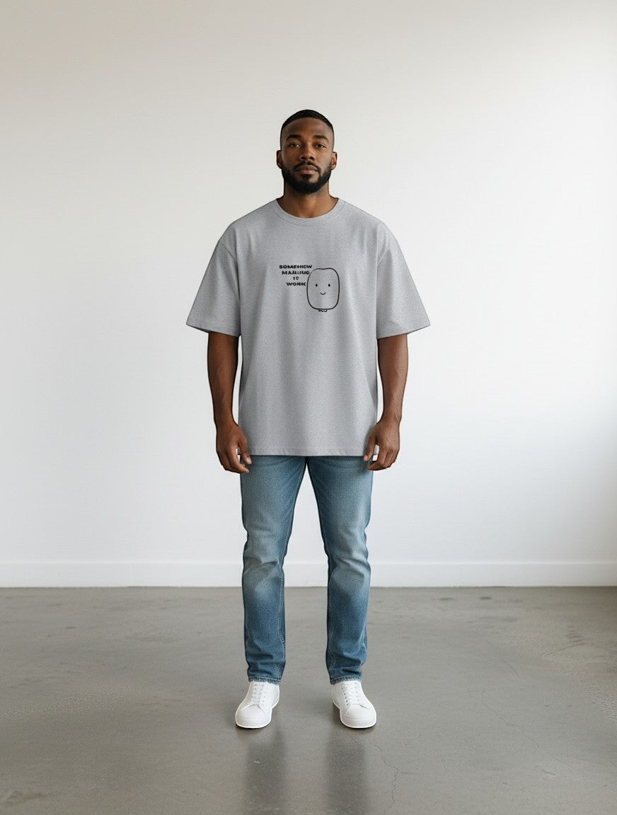mi-DONE grey oversized cotton t-shirt with a graphic print, worn by a man with blue jeans and white sneakers.