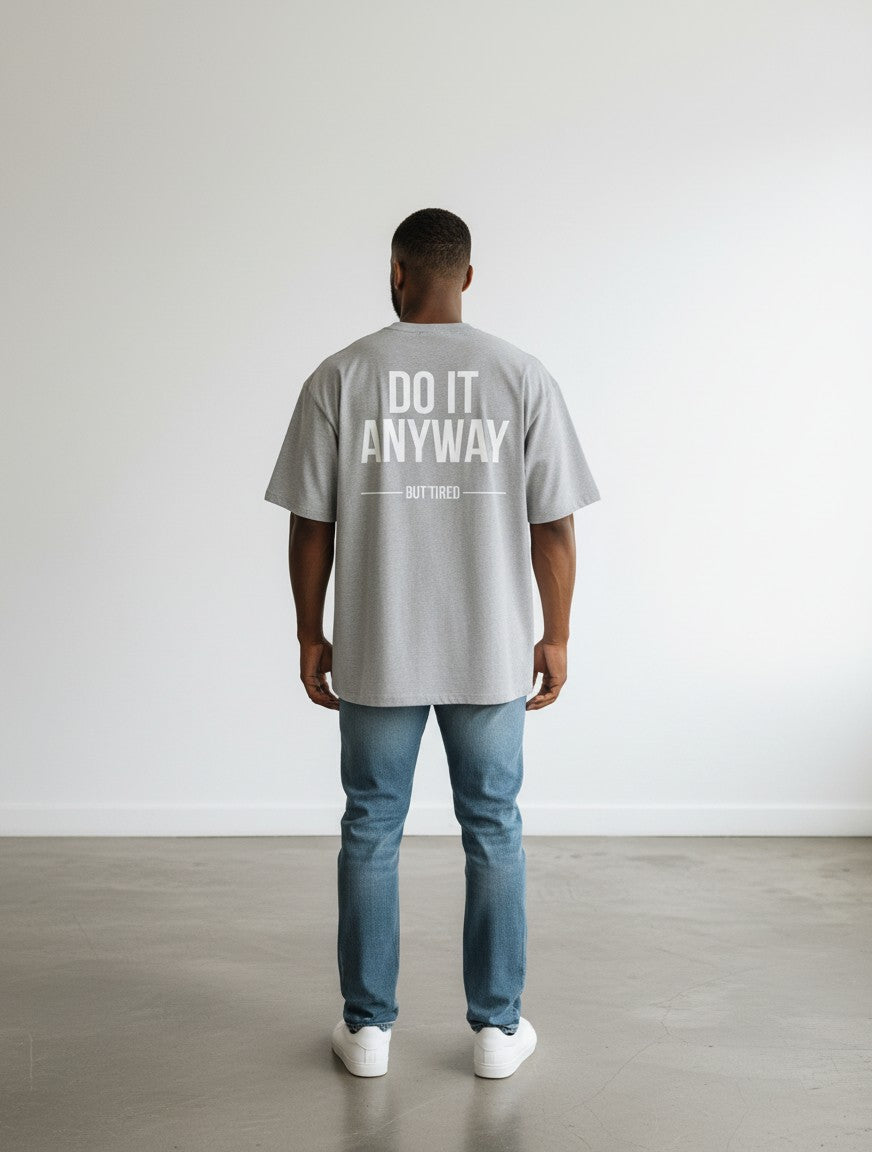 mi-DONE grey oversized cotton t-shirt with DO IT ANYWAY BUT TIRED graphic print on the back, worn by a man