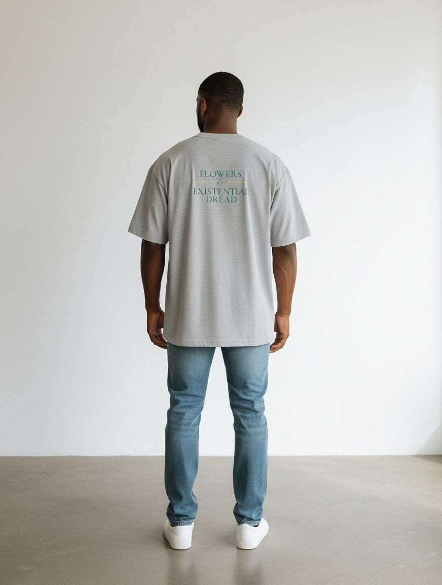 mi-DONE oversized grey cotton t-shirt with Flowers and Existential Dread back print worn by a man with blue jeans