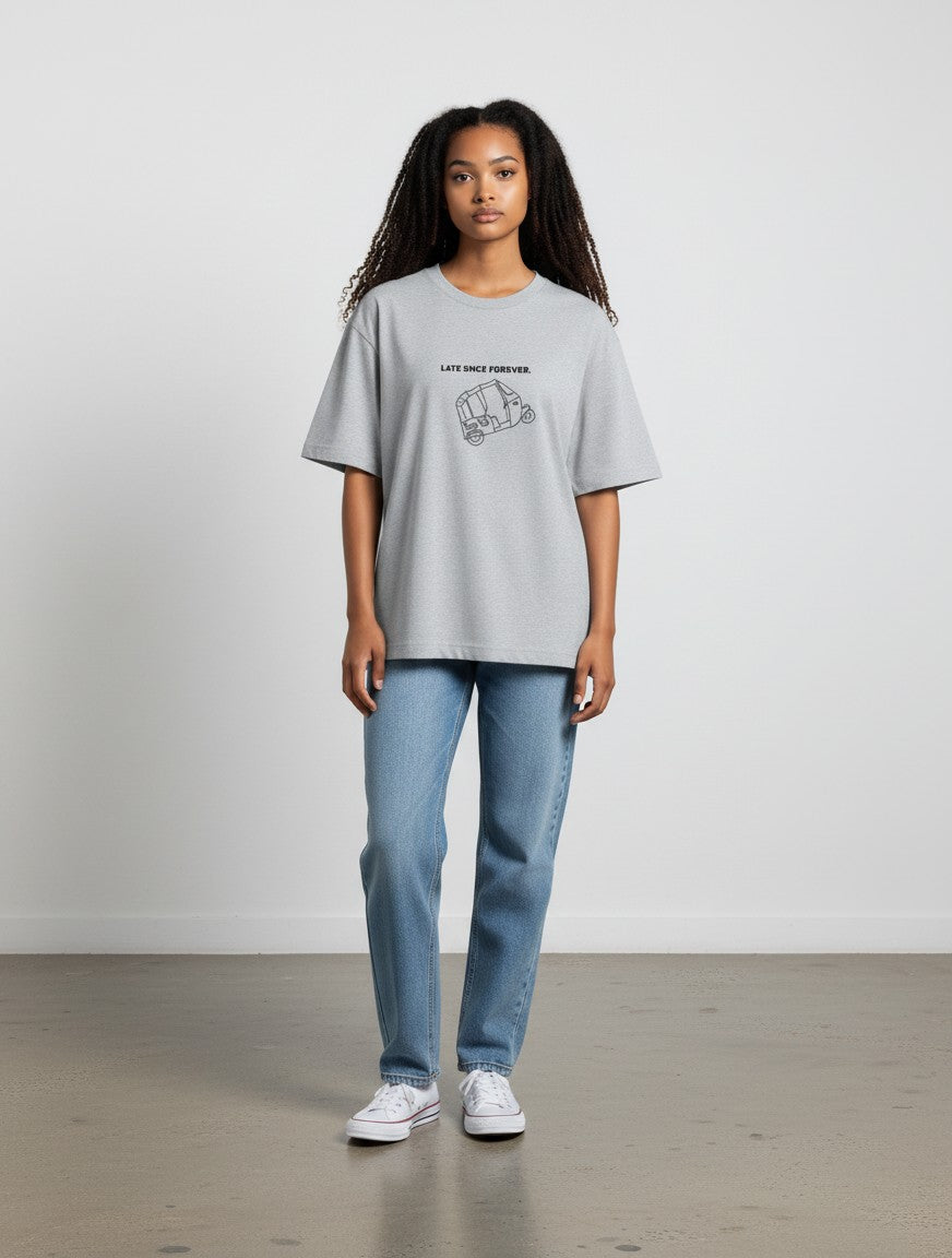 Model wearing a grey mi-DONE oversized cotton t-shirt with a Mumbai rickshaw graphic and text, paired with blue jeans.