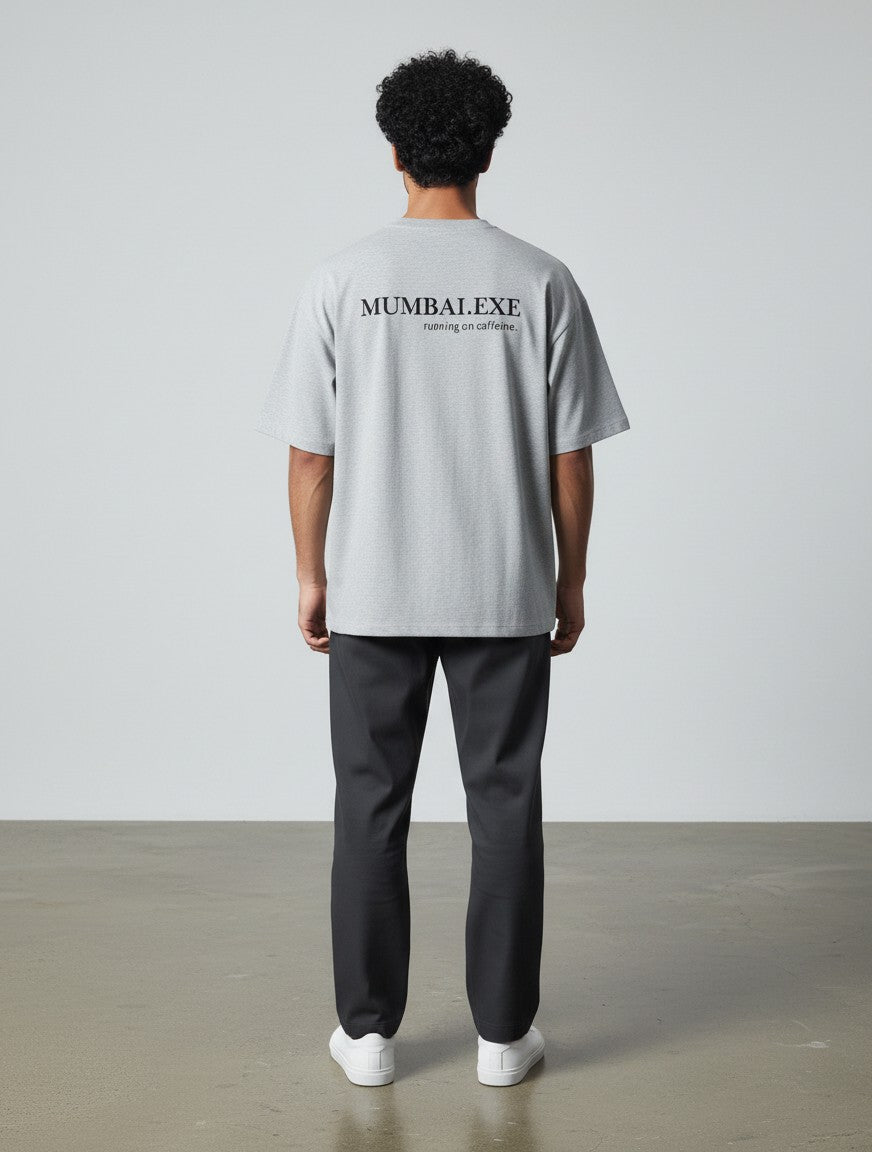 mi-DONE grey oversized cotton t-shirt with Mumbai.exe print on back worn by a man with dark curly hair
