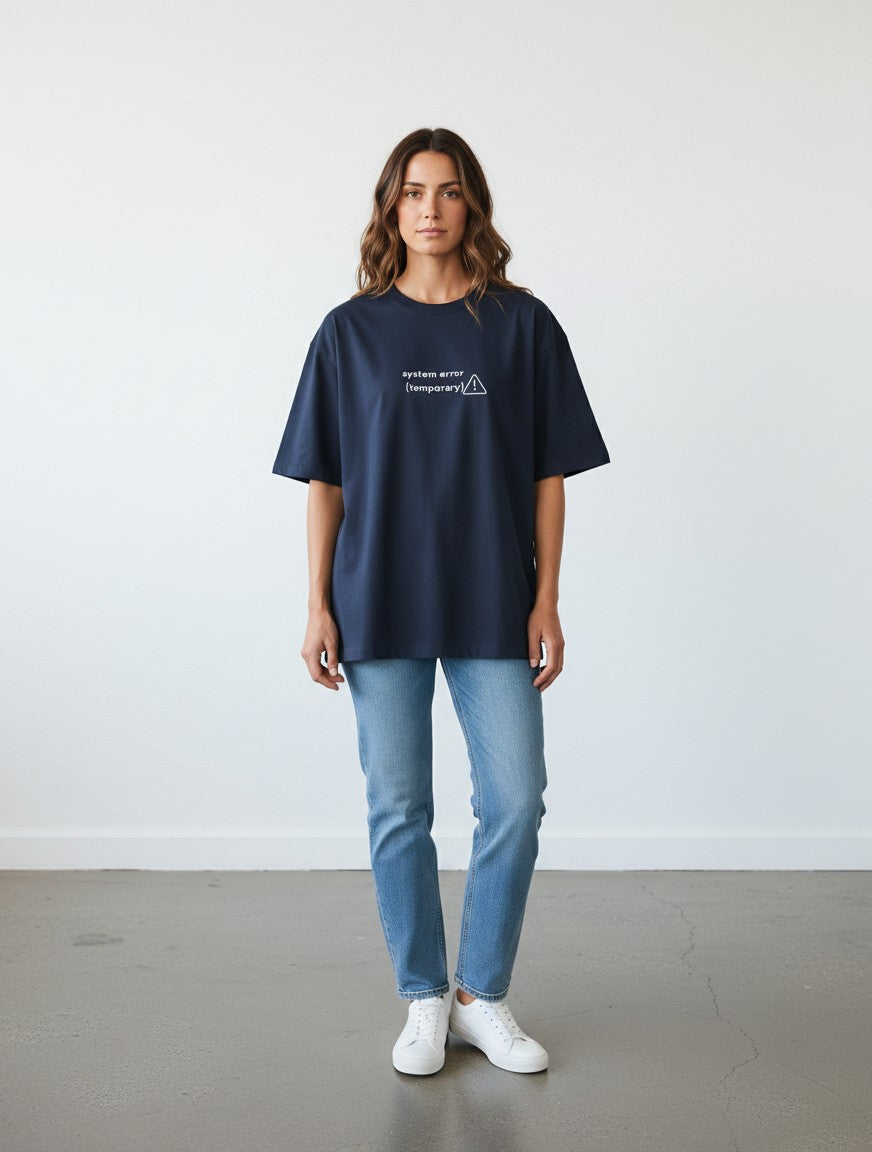 A model wearing a navy blue mi-DONE oversized cotton t-shirt with a white system error graphic, paired with jeans.