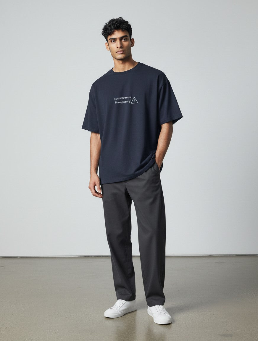 A male model wearing a navy blue mi-DONE oversized cotton t-shirt with a white graphic print and drop shoulders.