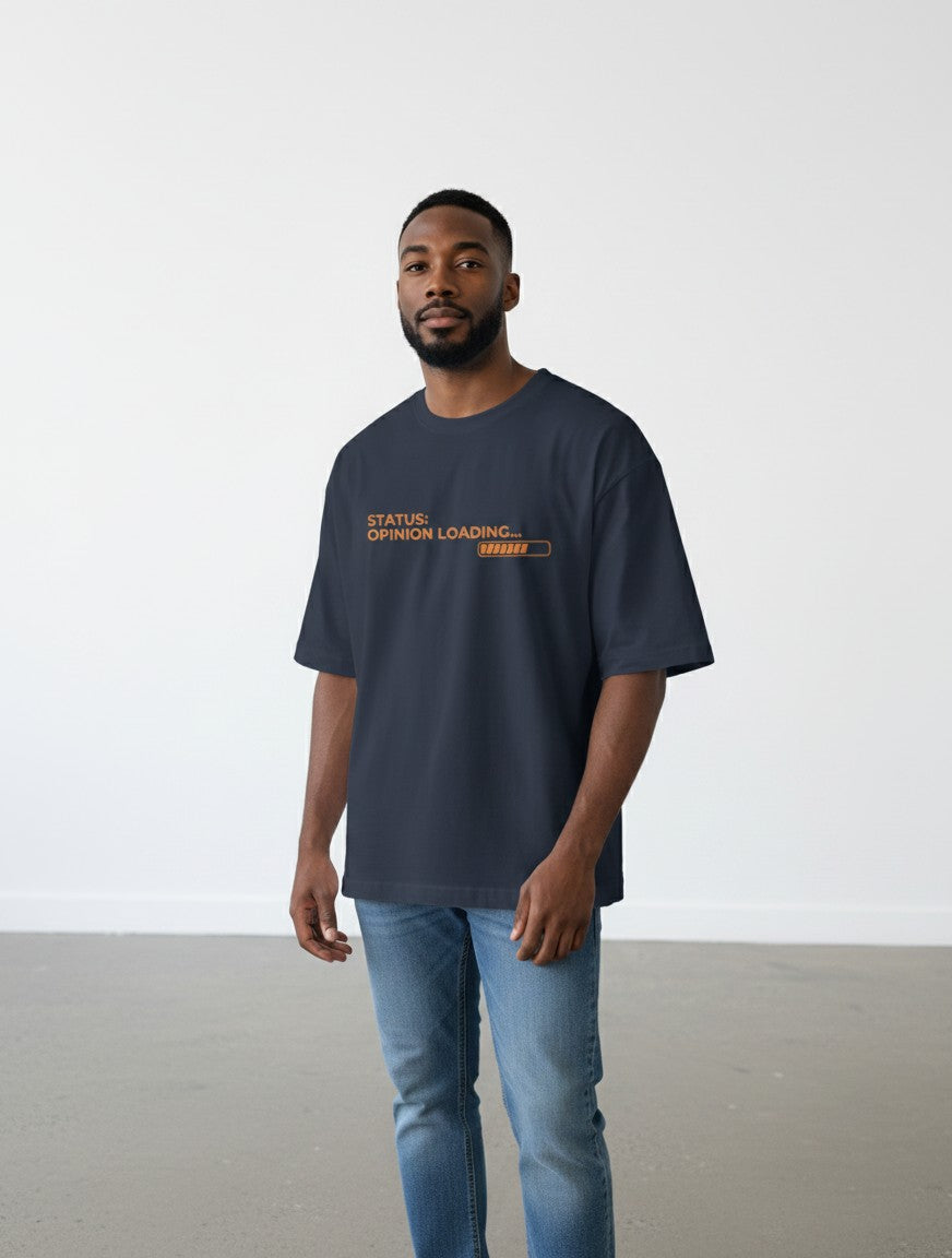 A man wearing a navy blue oversized mi-DONE cotton t-shirt with an orange Status: Opinion Loading graphic print.