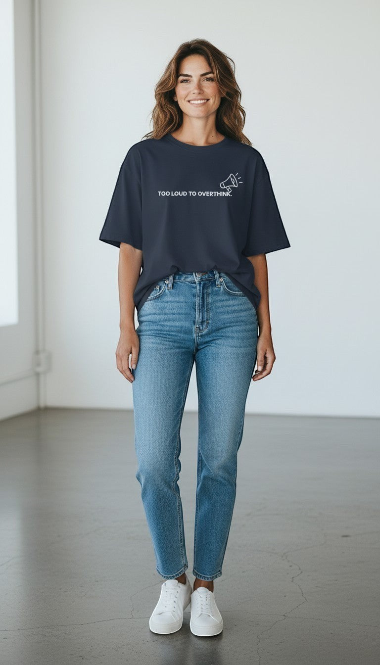 A woman wearing a navy blue mi-DONE oversized cotton t-shirt with Too Loud To Overthink text and a megaphone icon.