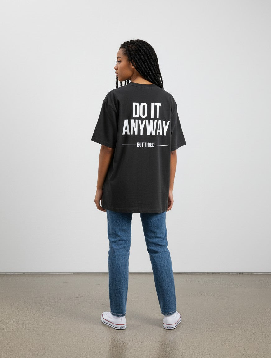 mi-DONE oversized black cotton t-shirt with white Do It Anyway But Tired graphic print on back worn with blue jeans