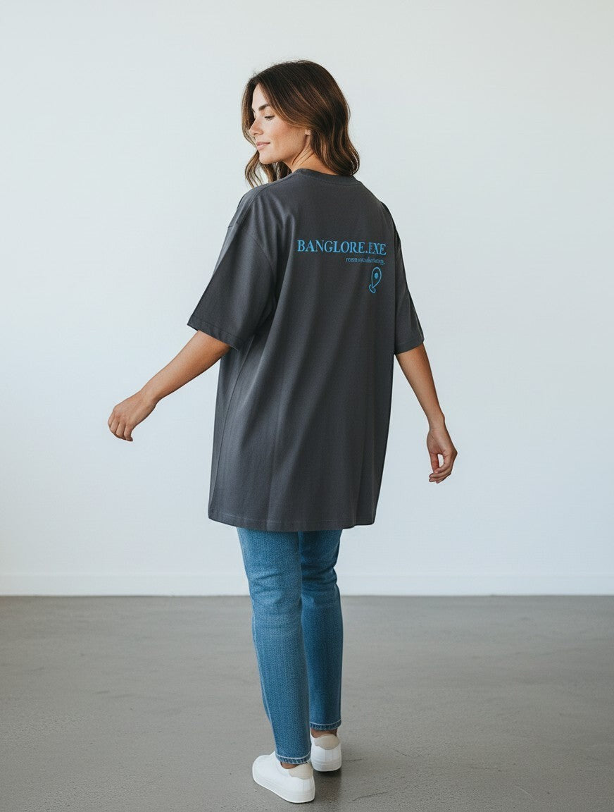 mi-DONE oversized charcoal grey cotton t-shirt with blue back graphic, worn by a woman with jeans and white sneakers