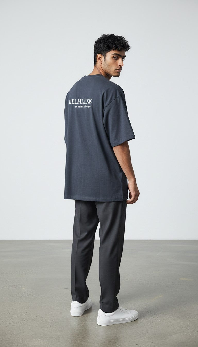 mi-DONE oversized charcoal grey cotton t-shirt with back graphic print worn by a man with dark trousers and sneakers
