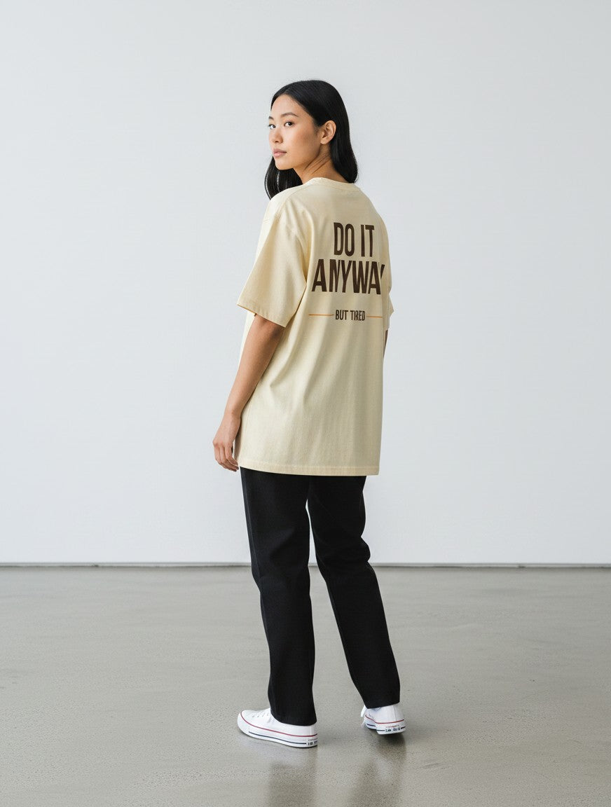 mi-DONE oversized cream cotton t-shirt with black text on the back, worn by a woman with black pants.