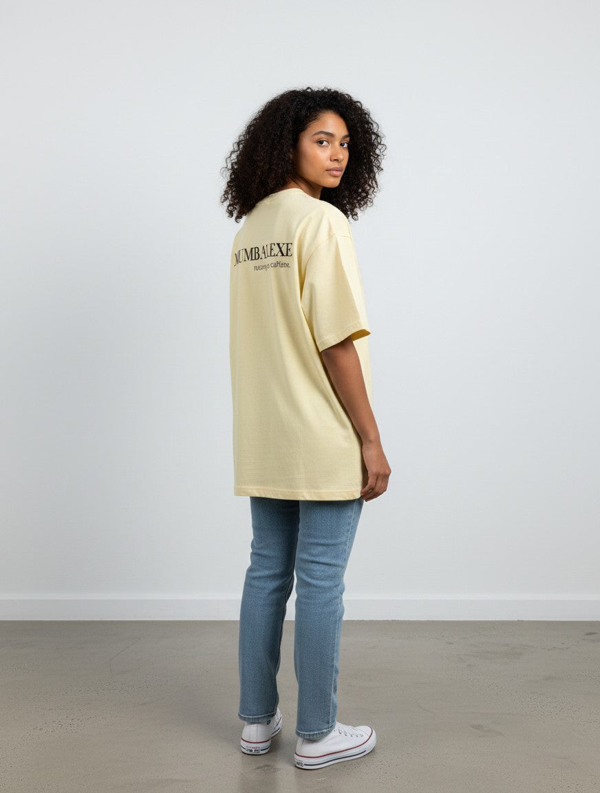 A model wearing a mi-DONE oversized cream cotton t-shirt with Mumbai graphic print on the back, paired with jeans.