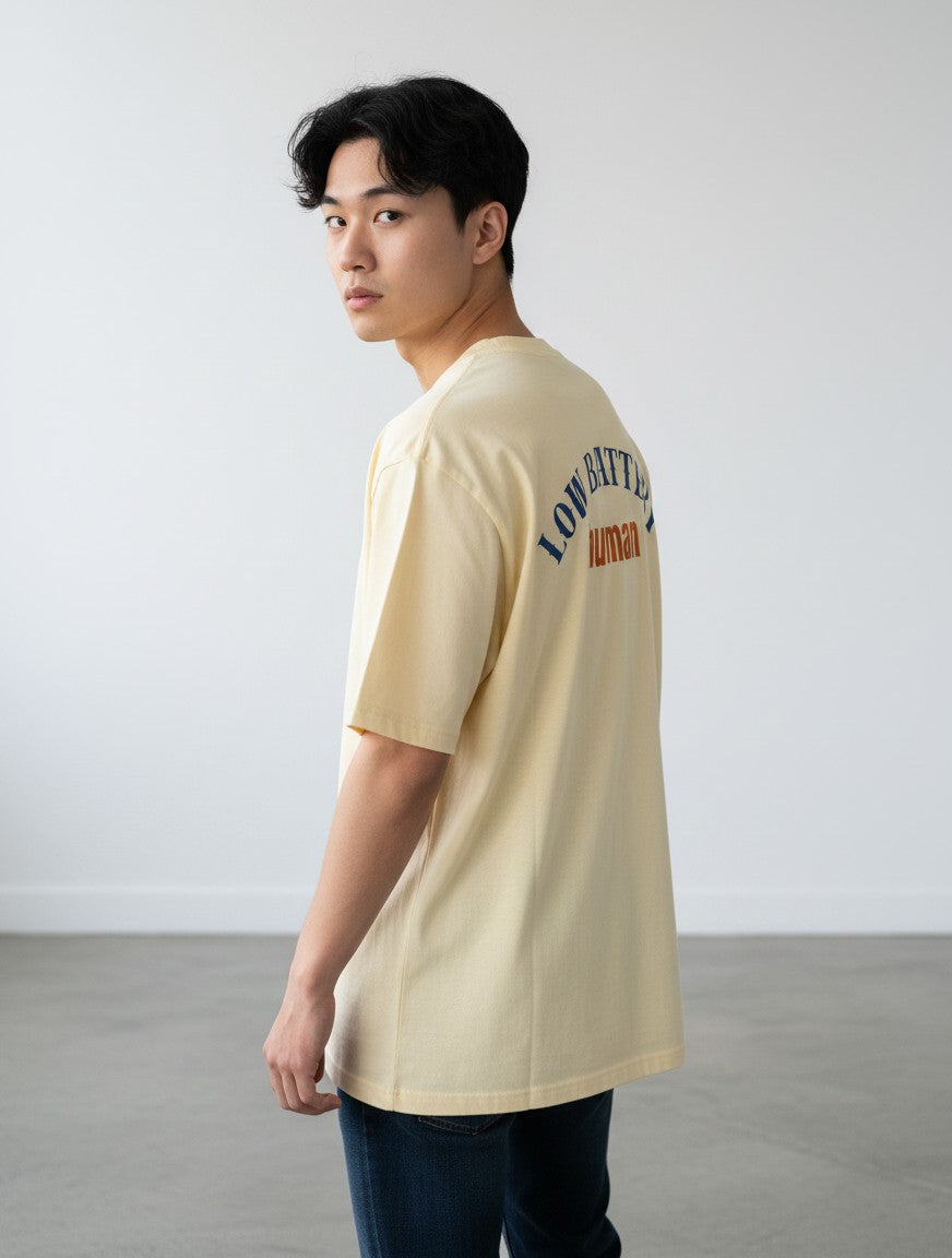 mi-DONE oversized cream cotton t-shirt with Low Battery graphic on the back worn by a man