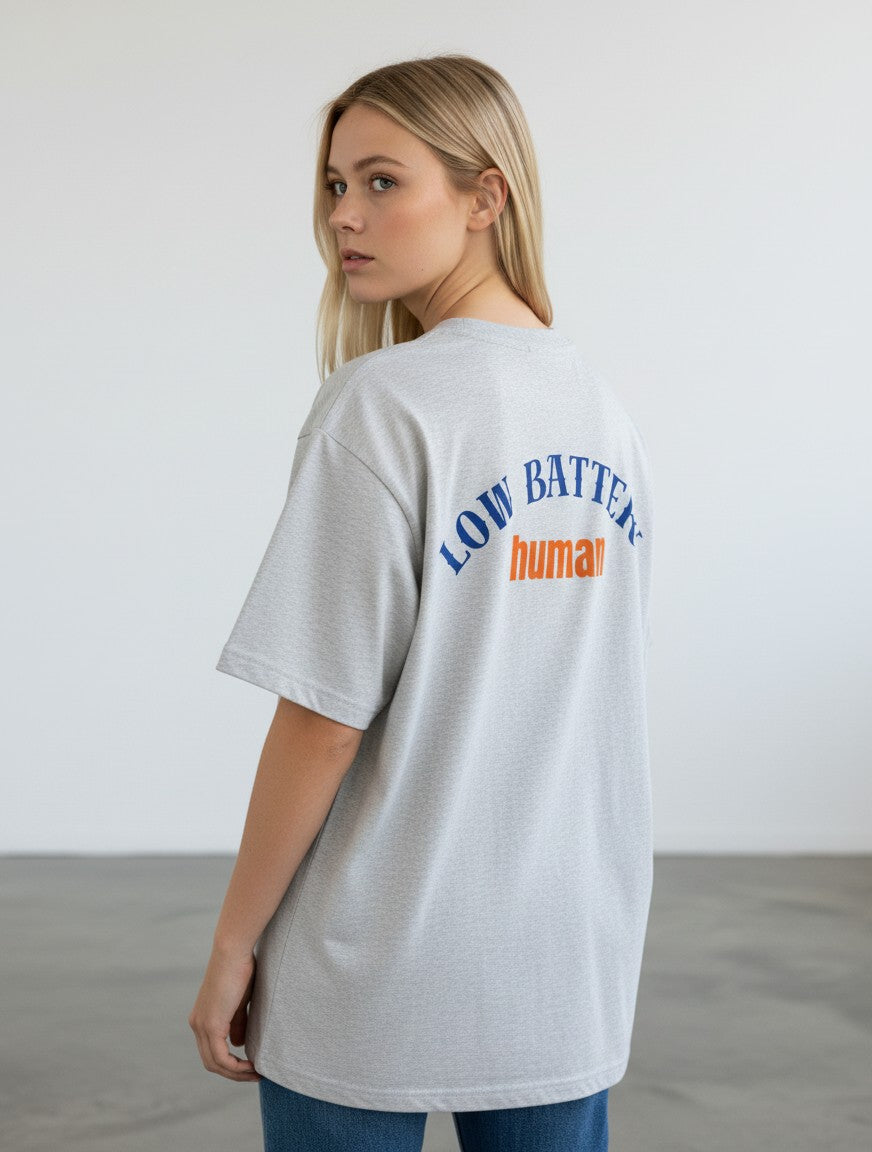 mi-DONE oversized grey cotton t-shirt with Low Battery human graphic print on the back, worn by a blonde woman