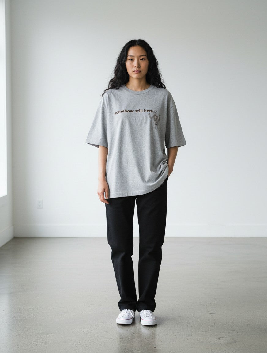 mi-DONE oversized grey cotton t-shirt with graphic print worn by a woman with black pants in a bright studio