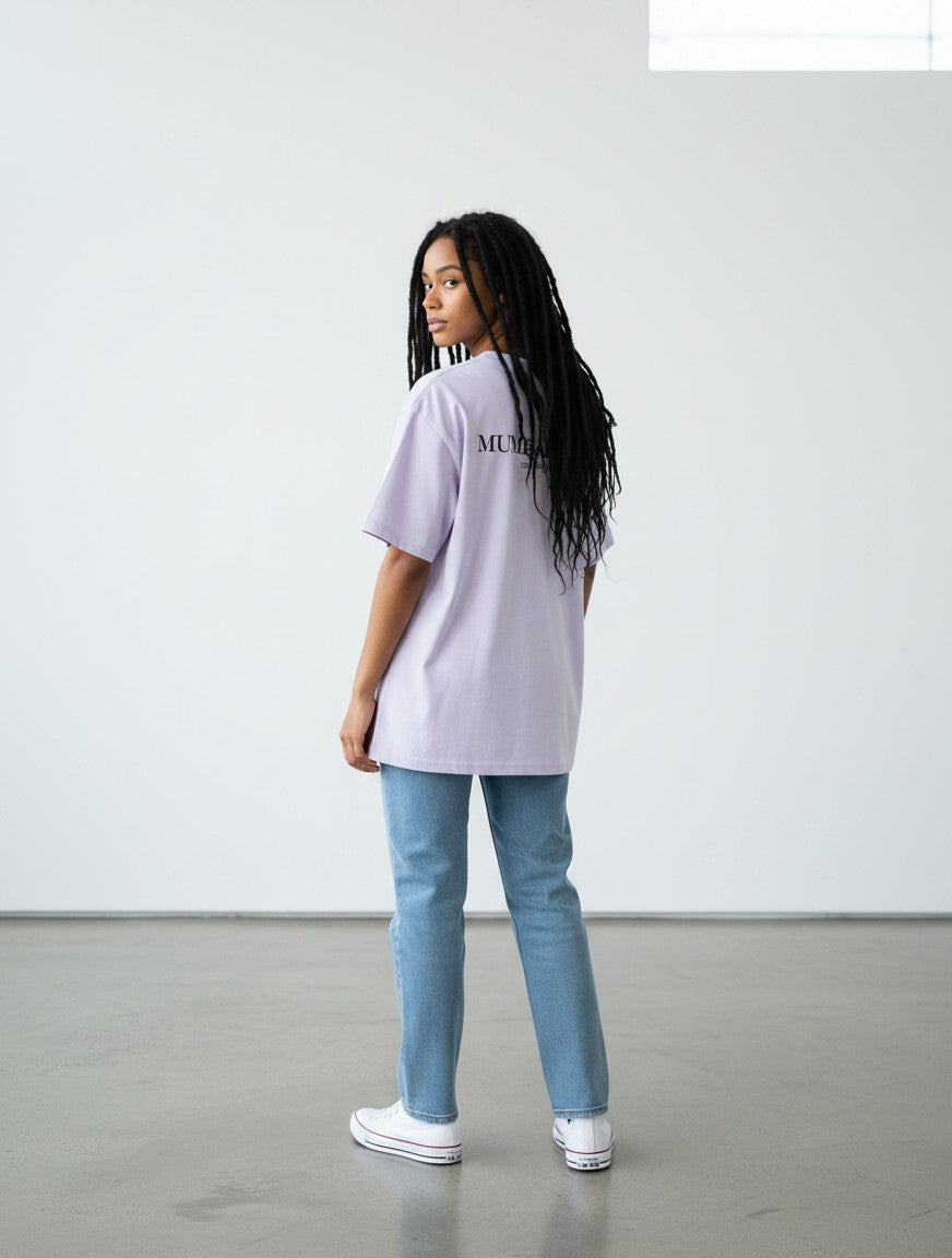 mi-DONE oversized lavender cotton t-shirt with Mumbai print on the back, worn by a woman with jeans and sneakers
