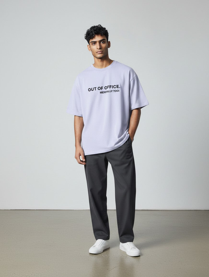 Model wearing a mi-DONE oversized lilac cotton t-shirt with Out of Office text print and drop shoulders