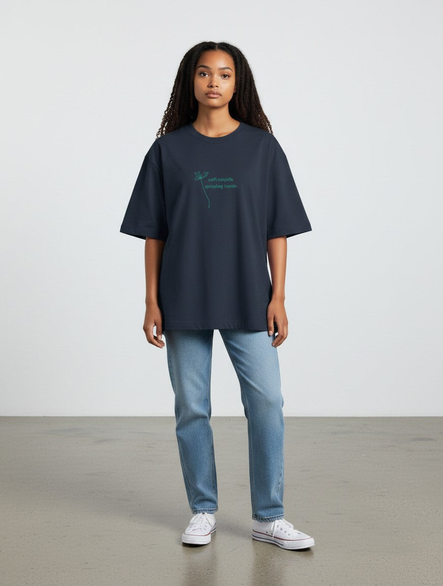 Model wearing a mi-DONE oversized navy blue cotton t-shirt with green text print, paired with blue jeans.