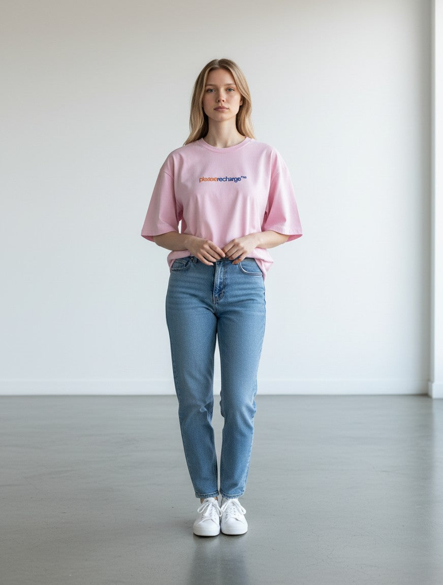 A woman wearing a mi-DONE oversized pink cotton t-shirt with a round neck and drop shoulders, paired with blue jeans.