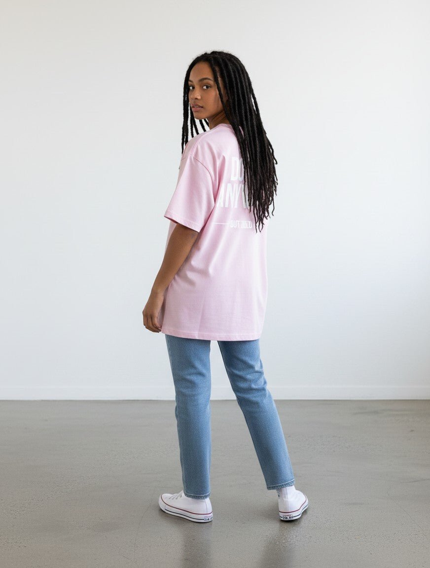 mi-DONE oversized pink cotton t-shirt with graphic print on back worn by a woman with dreadlocks and blue jeans