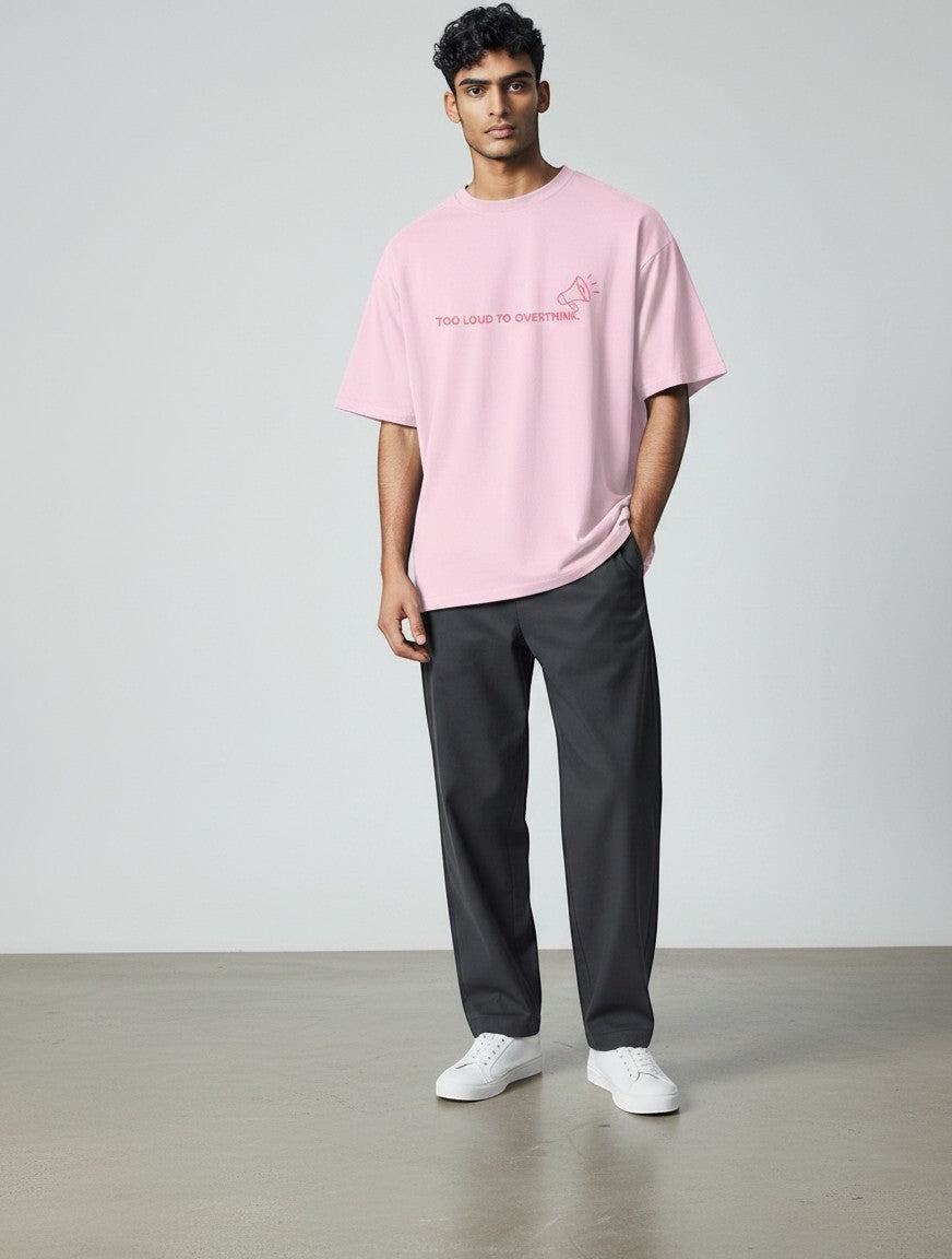 mi-DONE oversized pink cotton t-shirt with graphic print, worn by a man with dark trousers and white sneakers.