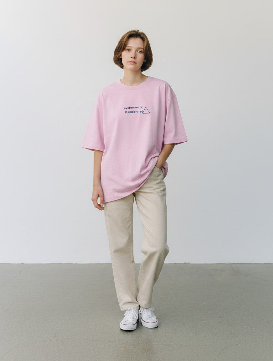 mi-DONE oversized light pink cotton t-shirt with System Error graphic print worn by a woman with beige trousers