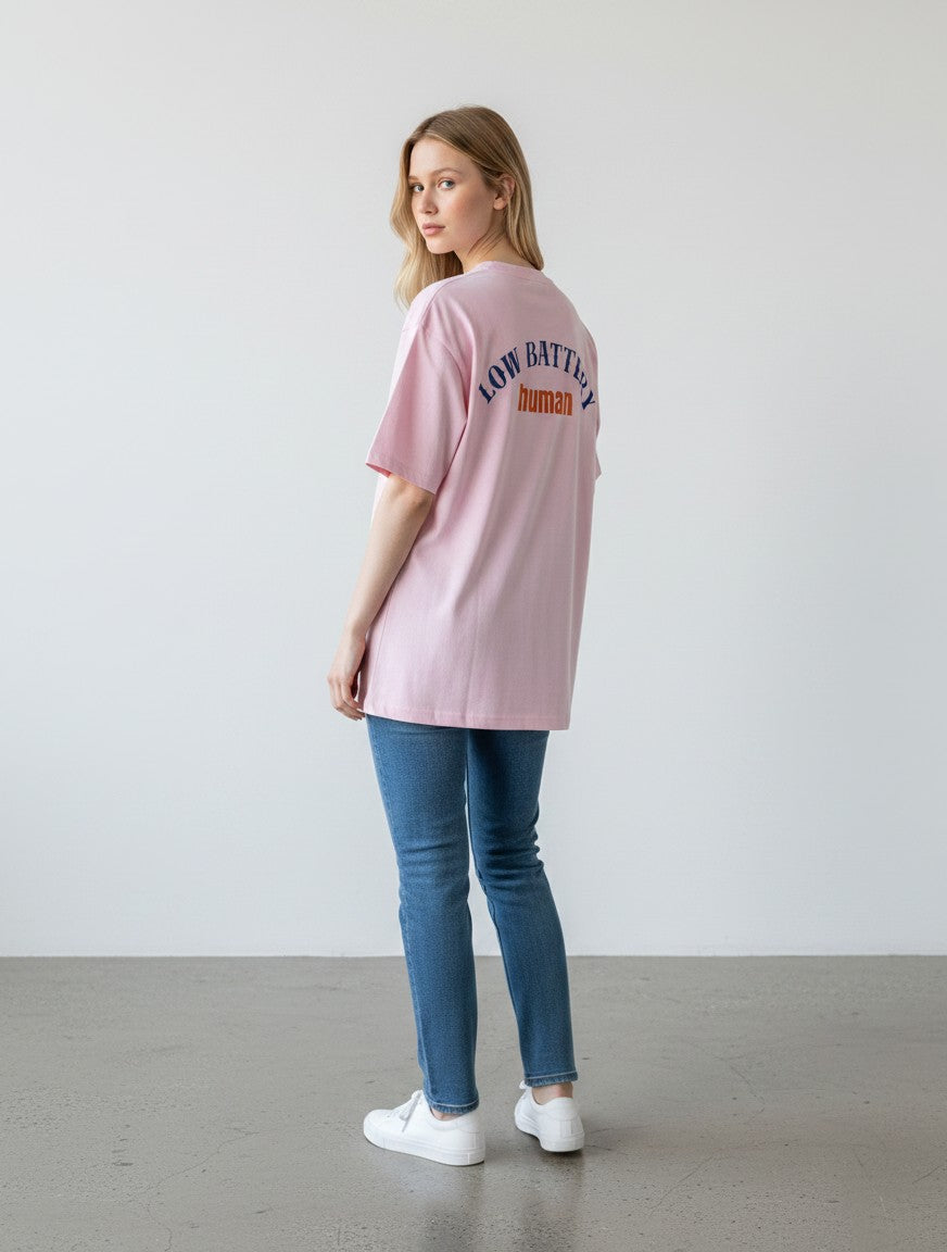 mi-DONE oversized pink cotton t-shirt with Low Battery human graphic print on back worn by a woman with blue jeans