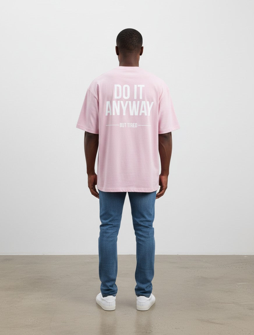 mi-DONE oversized light pink cotton t-shirt with white Do It Anyway But Tired text print on the back, worn by a man