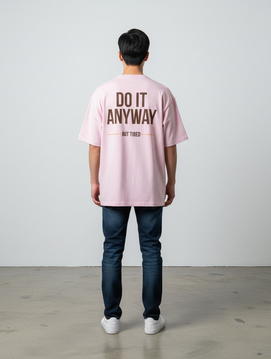 mi-DONE oversized pink cotton t-shirt with brown Do It Anyway But Tired graphic print on the back, worn by a man