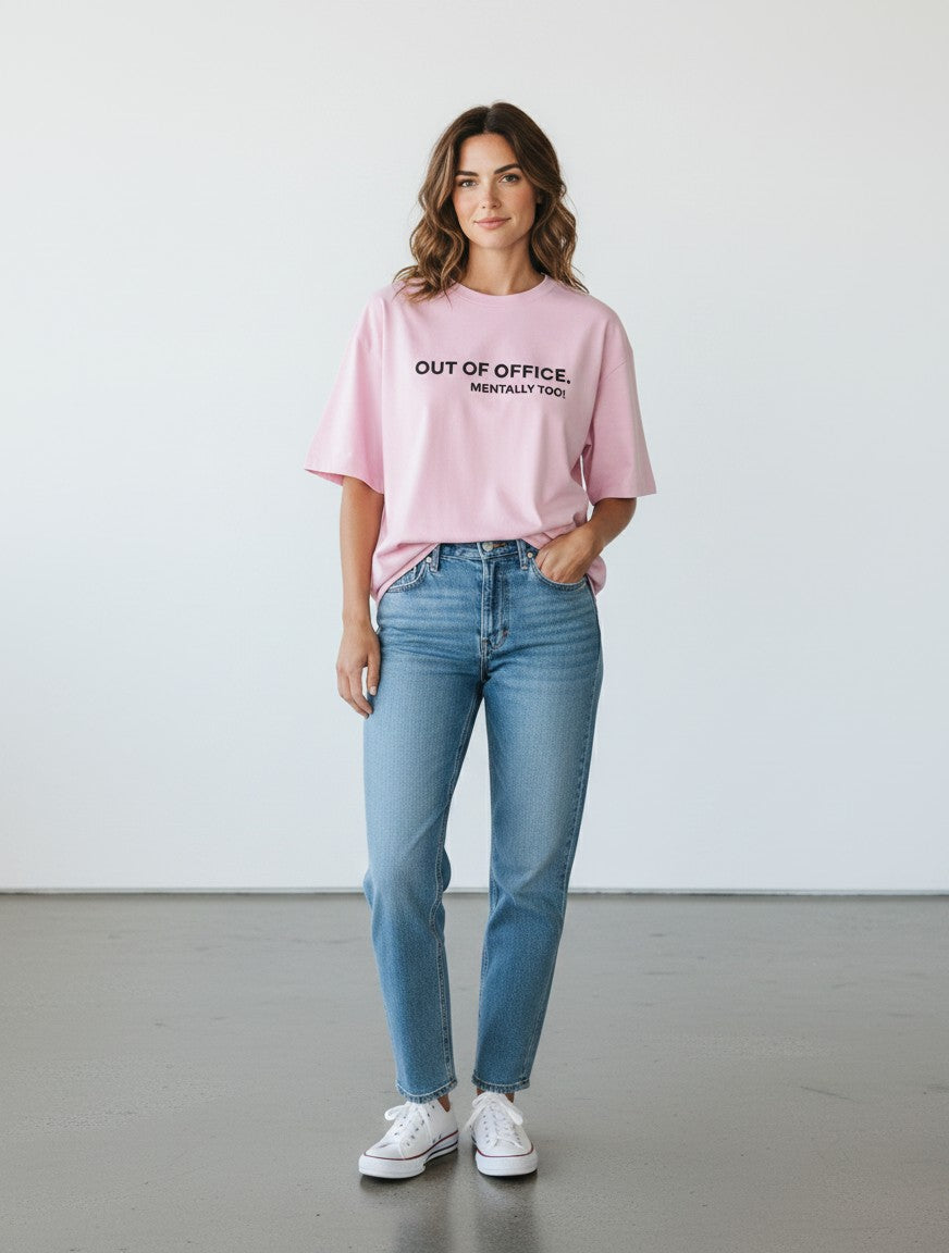 mi-DONE oversized pink cotton t-shirt with Out of Office text print worn by a woman with blue jeans and white sneakers