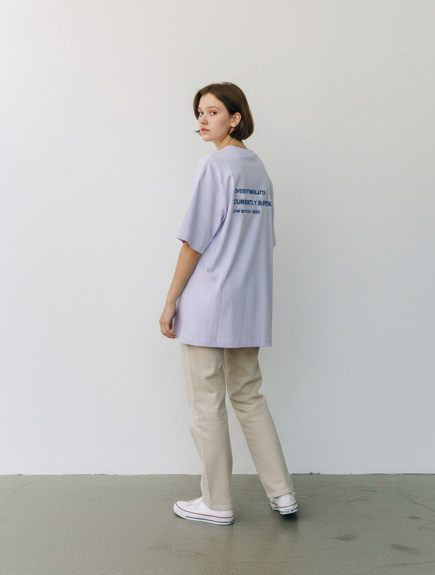 mi-DONE oversized light purple cotton t-shirt with back graphic print worn by a woman with beige trousers