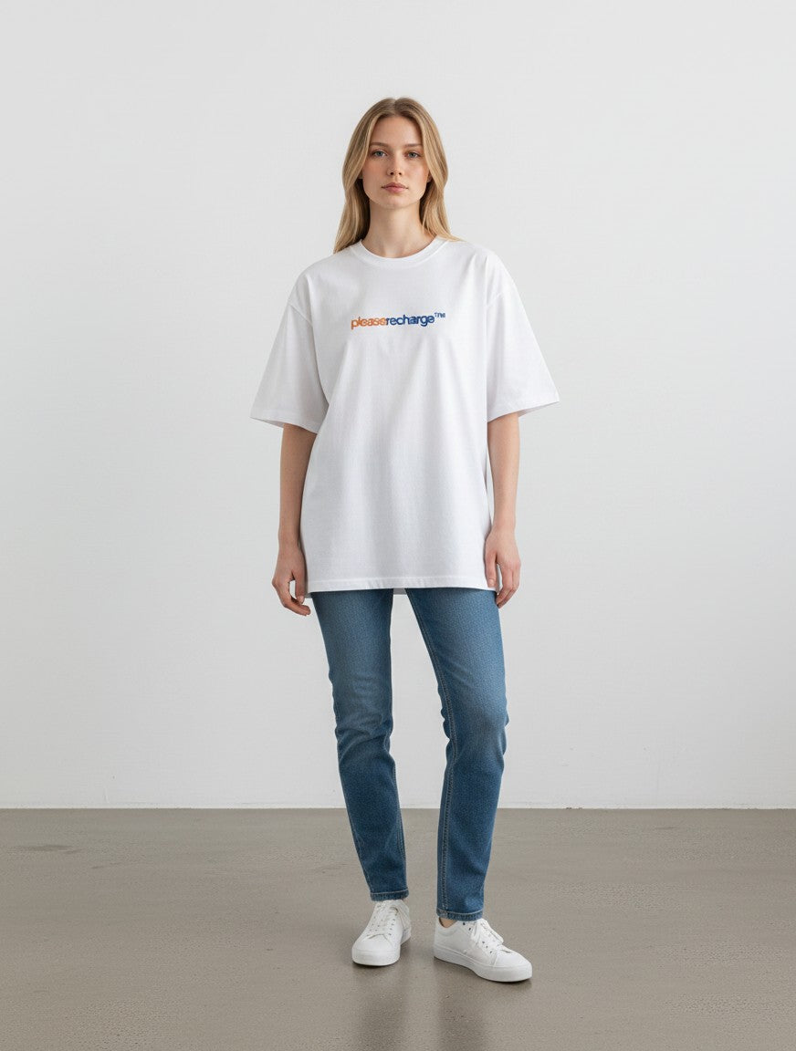 Model wearing a white mi-DONE oversized cotton t-shirt with a graphic print, paired with blue jeans and sneakers.
