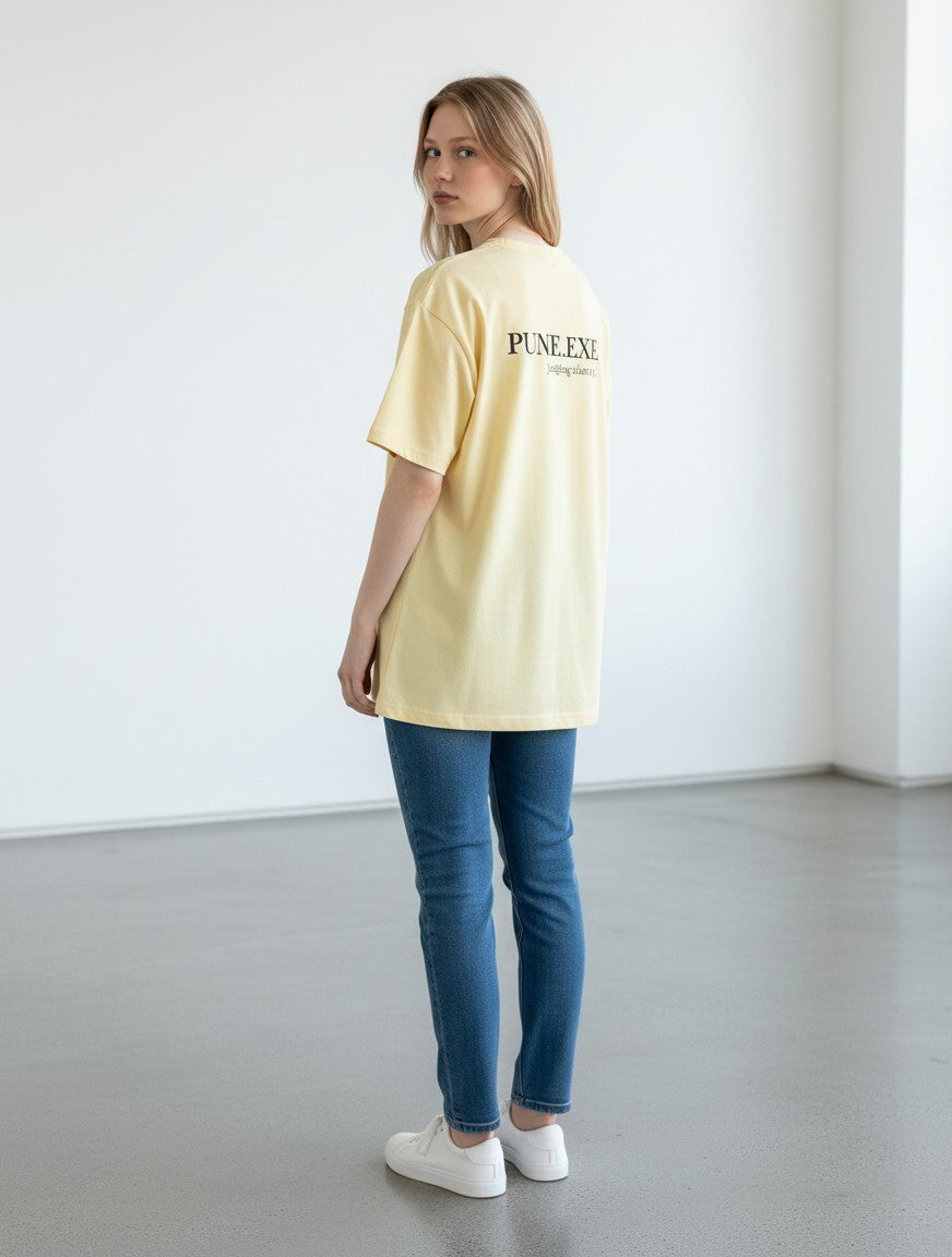 mi-DONE oversized yellow cotton t-shirt with PUNE.EXE graphic print on back, worn by a woman with blue jeans