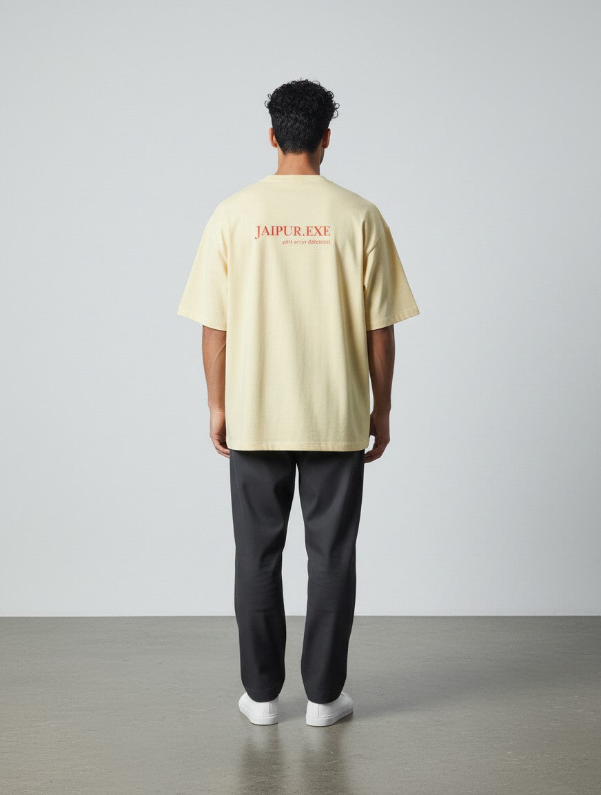 mi-DONE oversized yellow cotton t-shirt with Jaipur.exe graphic print on the back worn by a man with dark trousers