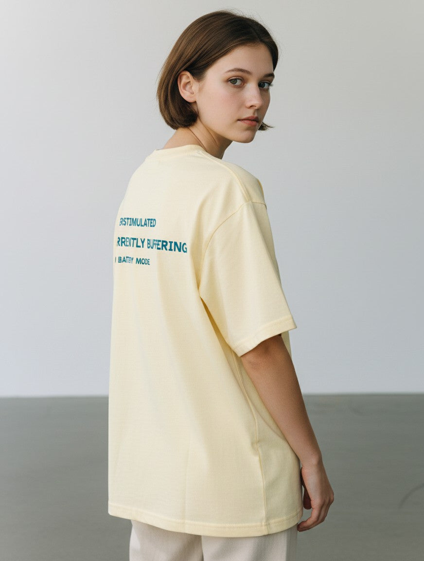 mi-DONE oversized pale yellow cotton t-shirt with System Error graphic print on the back worn by a woman