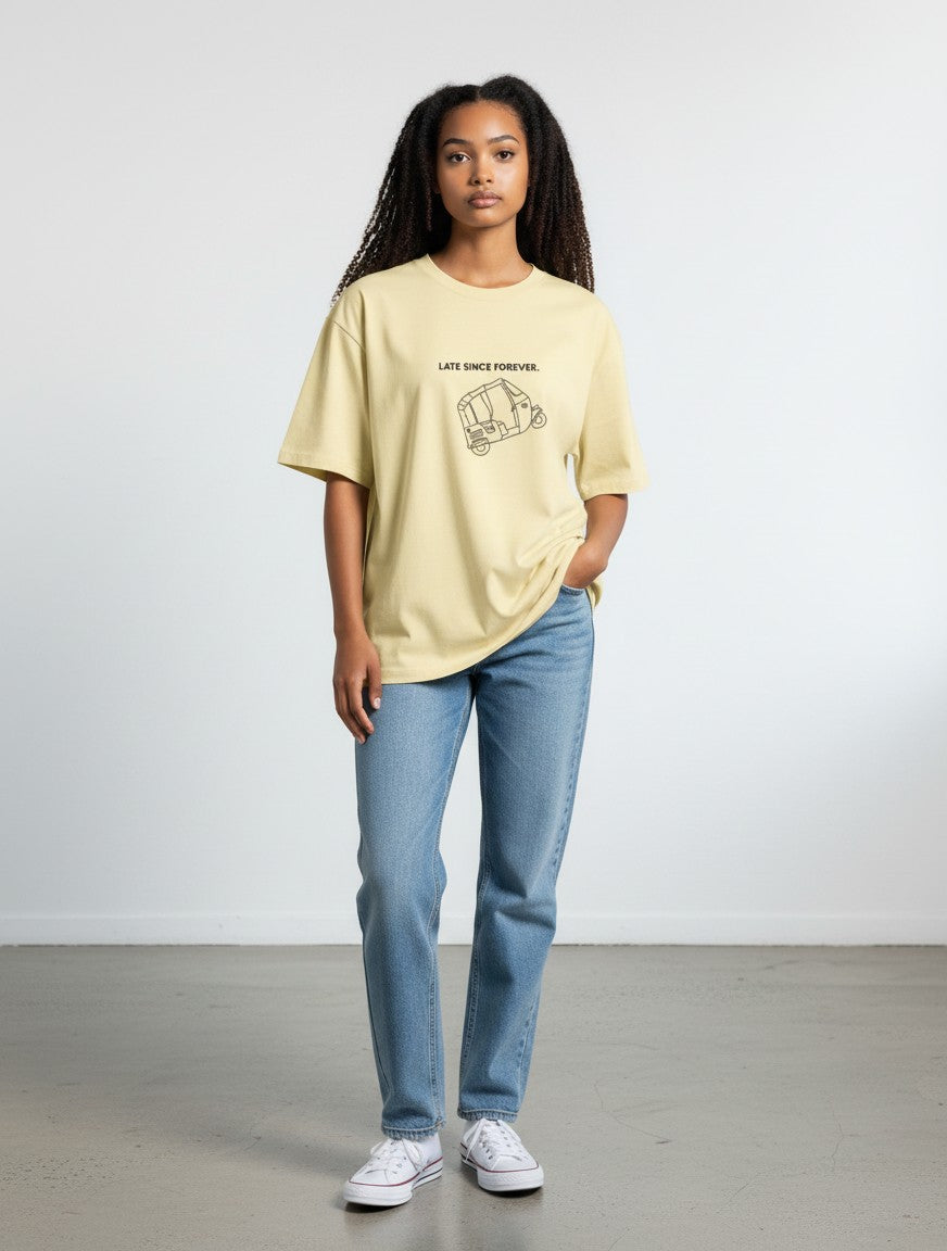 Model wearing a mi-DONE oversized yellow cotton t-shirt with a Mumbai rickshaw graphic and text, paired with blue jeans.