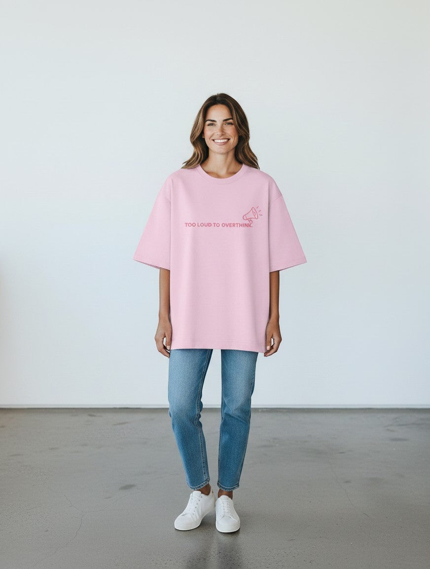 A woman wearing a pink mi-DONE oversized cotton t-shirt with the text Too Loud To Overthink and a megaphone graphic.