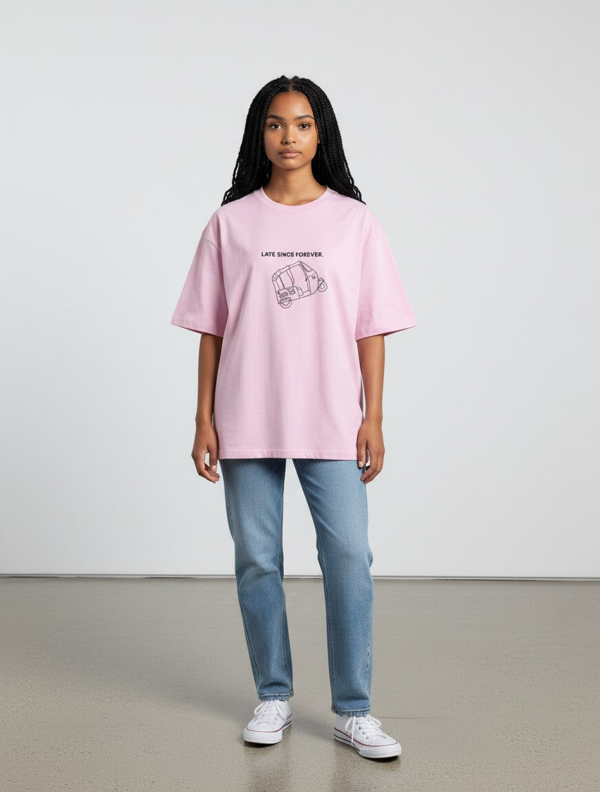 Model wearing a mi-DONE pink oversized cotton t-shirt with a Mumbai rickshaw graphic print and drop shoulders.